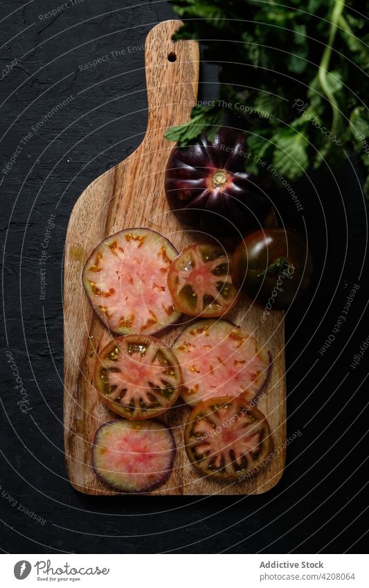 Black tomatoes and mint on cutting board black fresh vegetable slice food natural prepare healthy meal ingredient organic vitamin culinary nutrition product raw