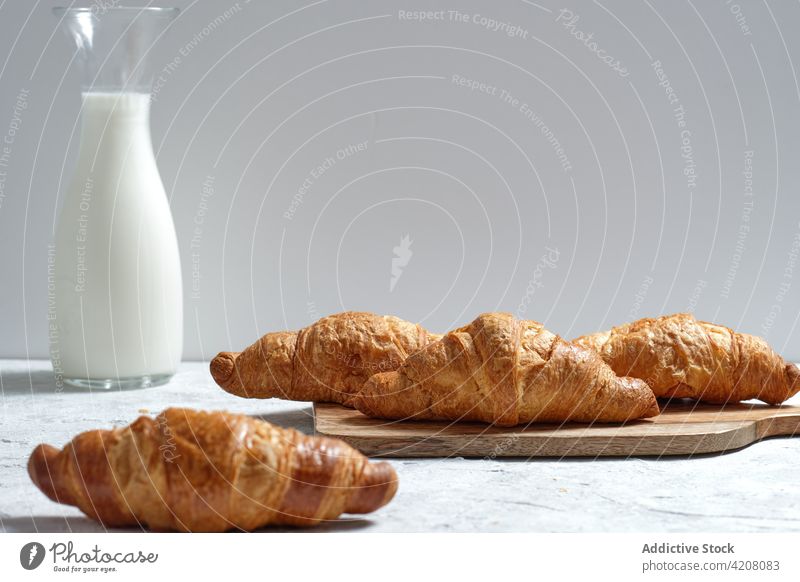 Tasty croissants on table at home milk breakfast kitchen tasty morning fresh baked meal food dairy beverage pastry bottle delicious drink dessert appetizing