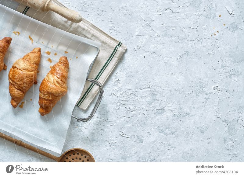 Appetizing sweet croissants placed on table dessert homemade baking paper kitchen pastry fresh baked bakery tray yummy metal appetizing nutrition tasty food