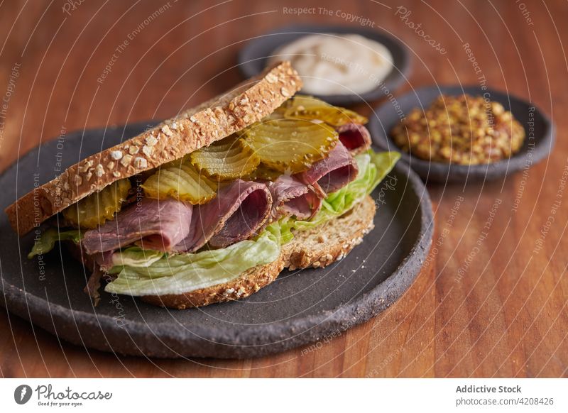 Closeup of a delicious pastrami, lettuce, ham and pickle sandwich lunch cheese bread meat food snack beef fast background tasty dinner american grilled salad