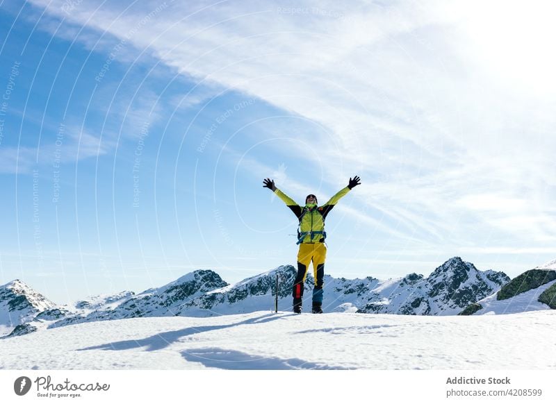 Happy climber enjoying freedom in snowy mountains mountaineer man happy active traveler rock nature male landscape sunny winter activity lifestyle adventure