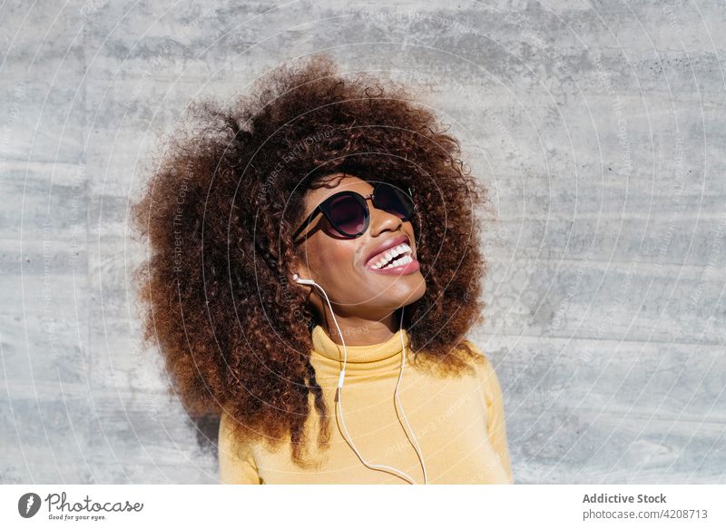 Glad trendy black woman laughing on grey background cheerful afro hairstyle charming enjoy colorful portrait glad content happy bright smile gentle tender vivid