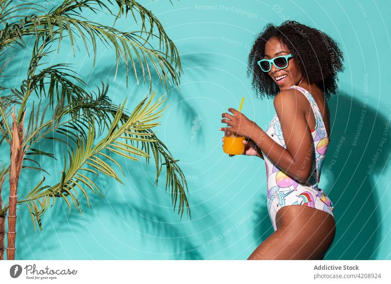 Gorgeous black woman in swimsuit sipping refreshing mocktail in studio style summer drink refreshment cool gorgeous enjoy happy cheerful outfit swimwear