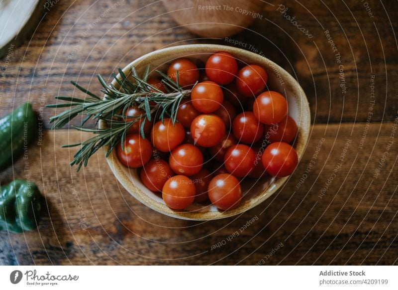 Cherry tomatoes with rosemary sprigs in bowl cherry tomato healthy food vegetable ingredient organic natural ripe harvest rustic herb aroma style onion bread