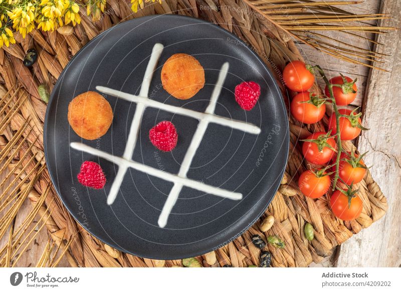 Delicious fritters with fresh raspberries on plate raspberry cream tic tac toe concept healthy food fast food healthy lifestyle vegan victory eco deep fried