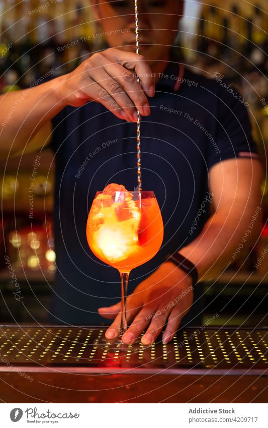 Young Asian bartender stirring grapefruit juice gin cocktail in the bar alcohol alcoholic aperitif barista barman beverage bottle business cap club copy space