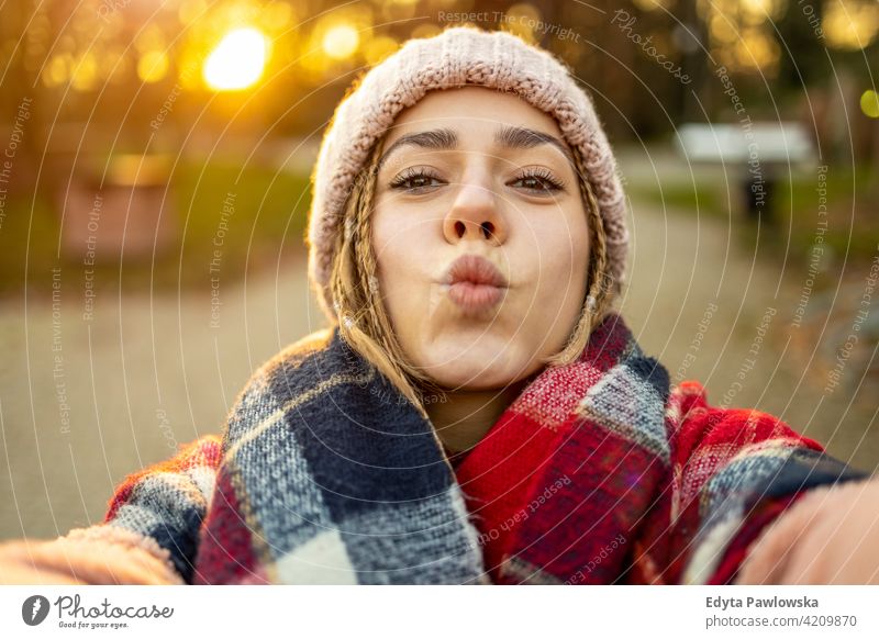 Portrait of a young woman in winter clothes and a hat wrapped in a scarf  with a big smile - a Royalty Free Stock Photo from Photocase