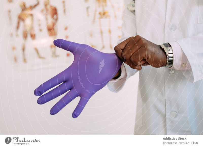Black man wearing latex glove in hospital sterile medical clean professional protect uniform male hand doctor job black prepare occupation african american work
