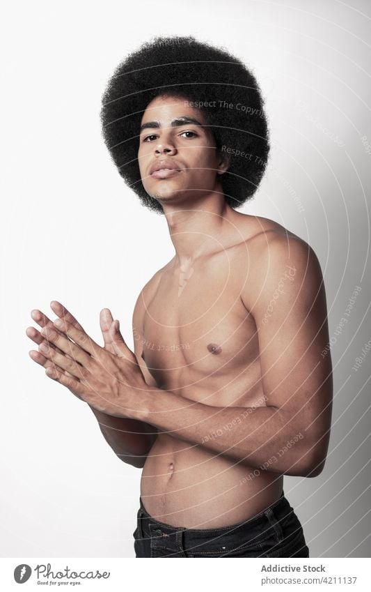 Masculine African American model with naked torso six pack masculine macho confident afro hairstyle man portrait fit shirtless self assured individuality cool