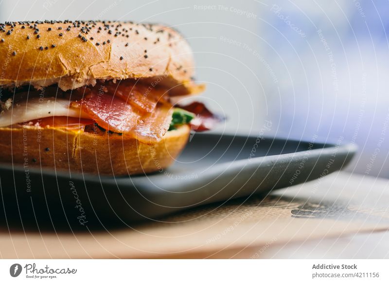 Tasty bagel sandwich on table in cafe meat serve tasty chicken bacon appetizing food meal delicious salad plate cheese culinary nutrition portion gastronomy
