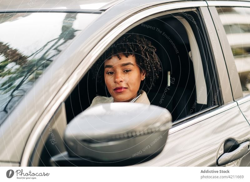Black happy woman driving car trendy fashion female african american drive black automobile style charismatic garment vehicle shirt elegant carefree transport
