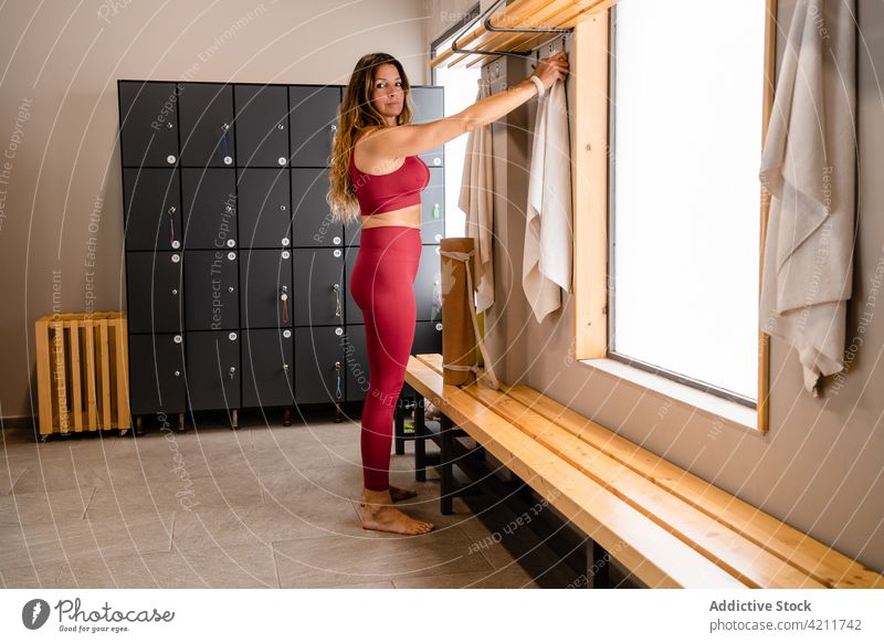 Sportswoman taking towel in gym locker room after training sportswoman activewear sporty wellness physical sportswear healthy female workout wellbeing slim