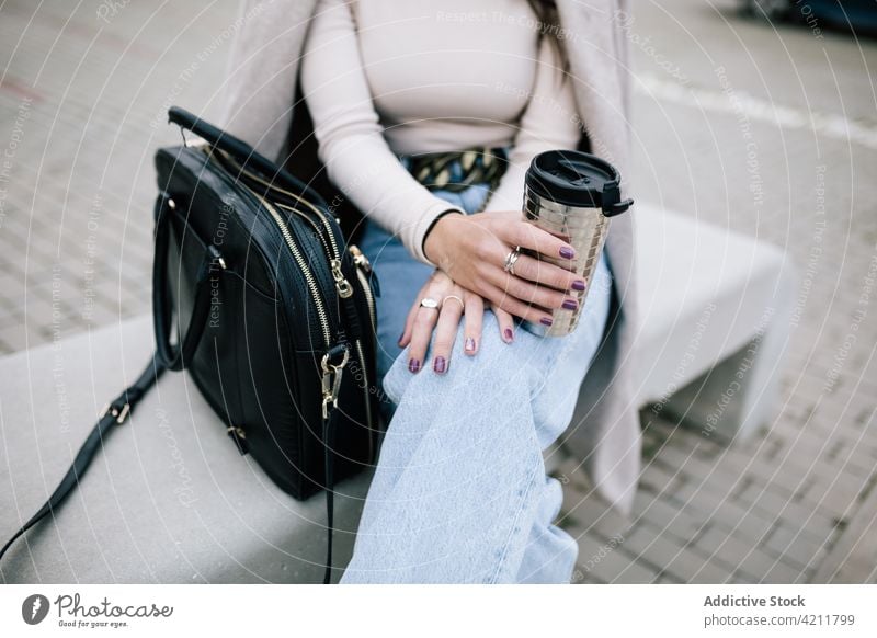 Anonymous businesswoman sitting on bench with takeaway coffee in cup city trendy entrepreneur to go female outfit beverage drink hot drink street urban modern