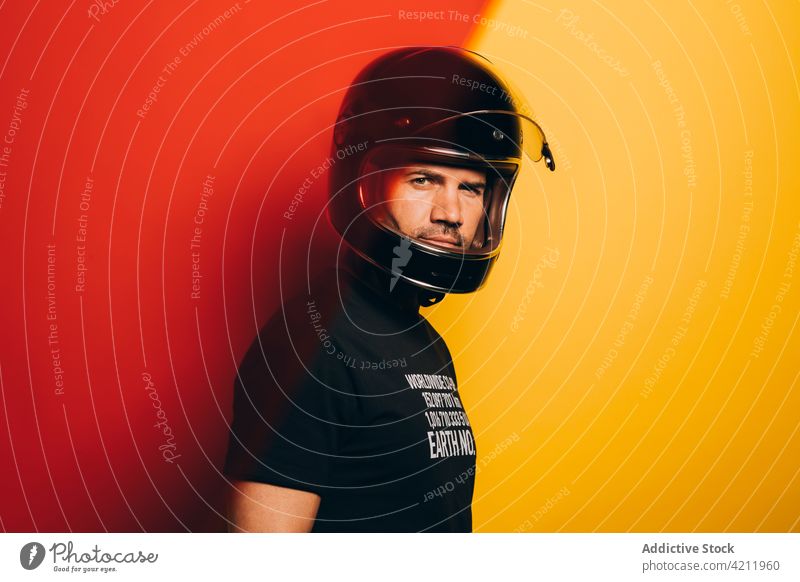 Serious male biker in helmet looking at camera man racer confident serious protect brutal motorcyclist black adult style trendy ethnic macho rider masculine