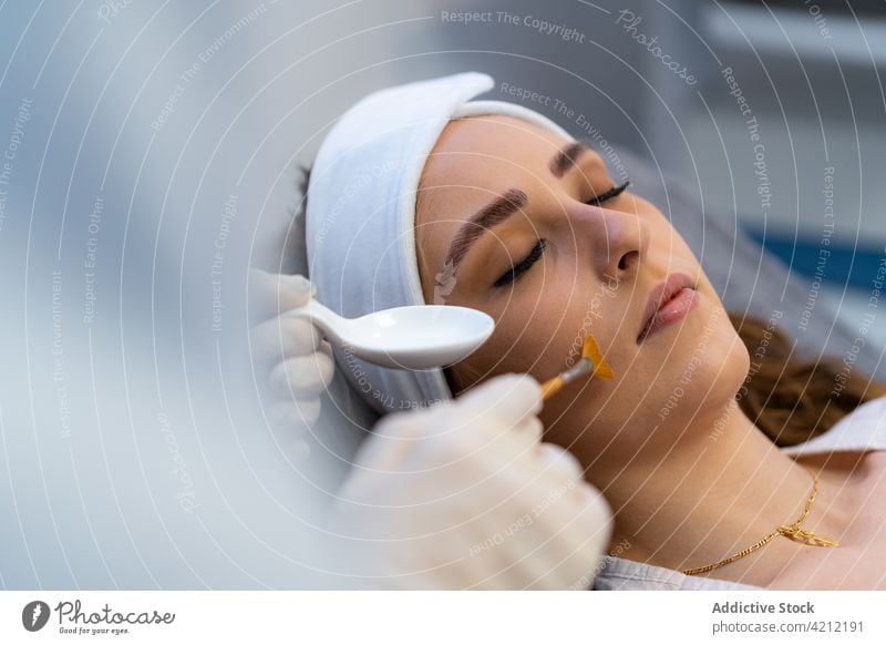 Crop beautician applying acid peeling on face of woman beauty skin care cosmetology treat exfoliate dermatology female procedure client clinic modern