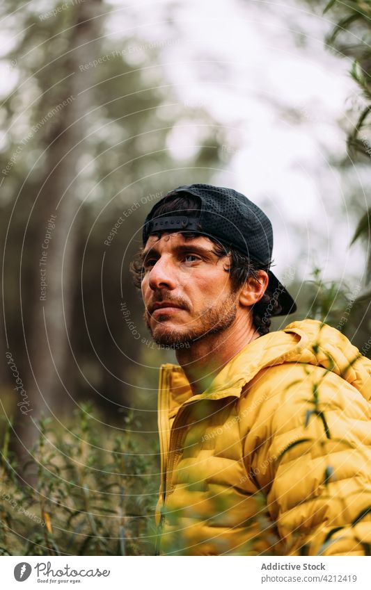 Man with cap looking away on the mountain man portrait trekking person activity nature young adult landscape travel relaxation active jacket traveler vacation