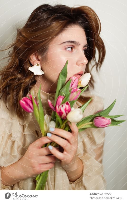 Peaceful woman with bunch of tulips in studio flower bouquet spring tranquil peaceful romantic female floral fresh blossom nature petal bloom gift natural
