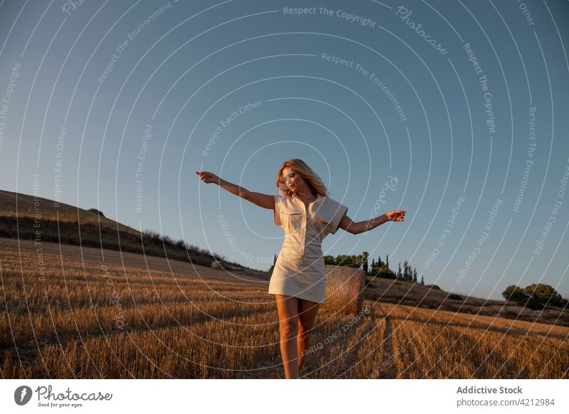 Serene woman standing on dry field in countryside serene peaceful relax meadow rural summer harmony female calm nature young tranquil lady freedom carefree