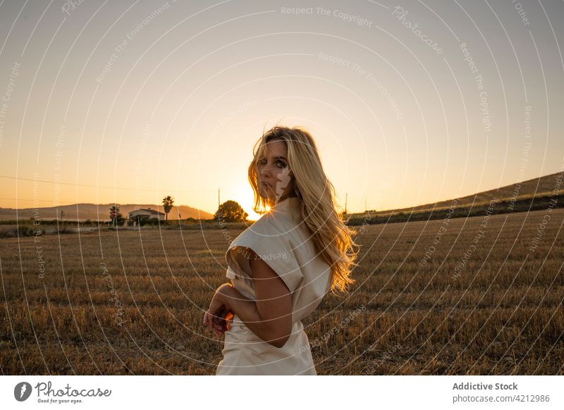 Serene woman standing on dry field in countryside serene peaceful relax meadow rural summer harmony female calm nature young tranquil lady freedom carefree