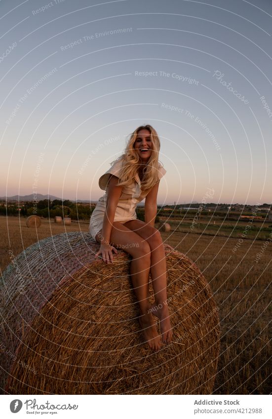 Serene woman sitting on haystack in countryside peaceful field Haystack relax meadow rural summer harmony calm nature young tranquil lady dry freedom carefree