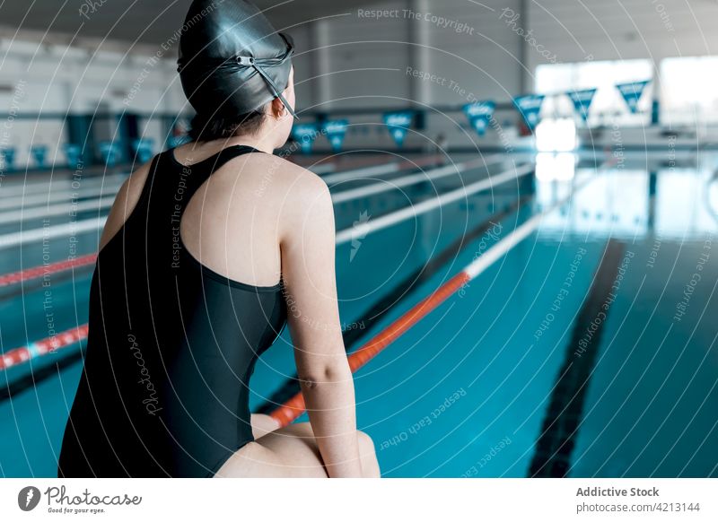 Swimmer sitting on the edge of the pool sport water swimmer female woman athlete young swimwear training blue people cap competition person lifestyle healthy