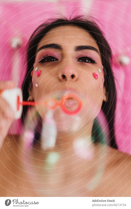 Portrait of a make-up brunette woman blowing soap bubbles makeup portrait face pink beautiful beauty girl female model lips fashion cosmetic style skin young