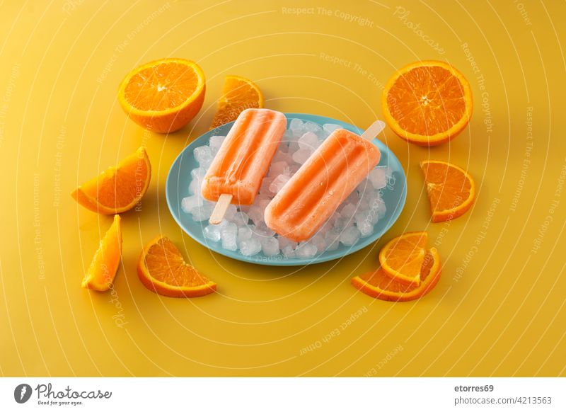 Orange popsicles on blue plate background cake cold colorful cool cream dessert flavor food fresh frosty frozen fruit homemade ice icecream iced juice lolly