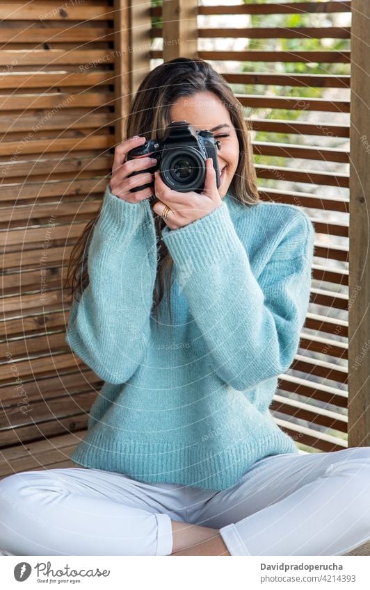 Young woman taking photo with camera from terrace photography take photo photo camera cheerful happy hobby enjoy device gadget capture smile positive lifestyle
