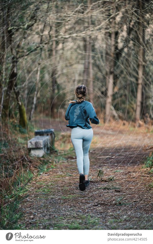 Sporty woman running in forest sporty active training fitness activewear workout woods activity runner sportswoman jog healthy path trail wellness jogger