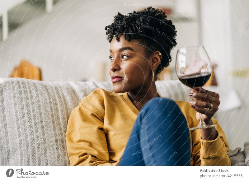 Black woman with glass of wine at home wineglass chill red wine enjoy drink weekend female black ethnic african american beverage happy sit booze pleasure