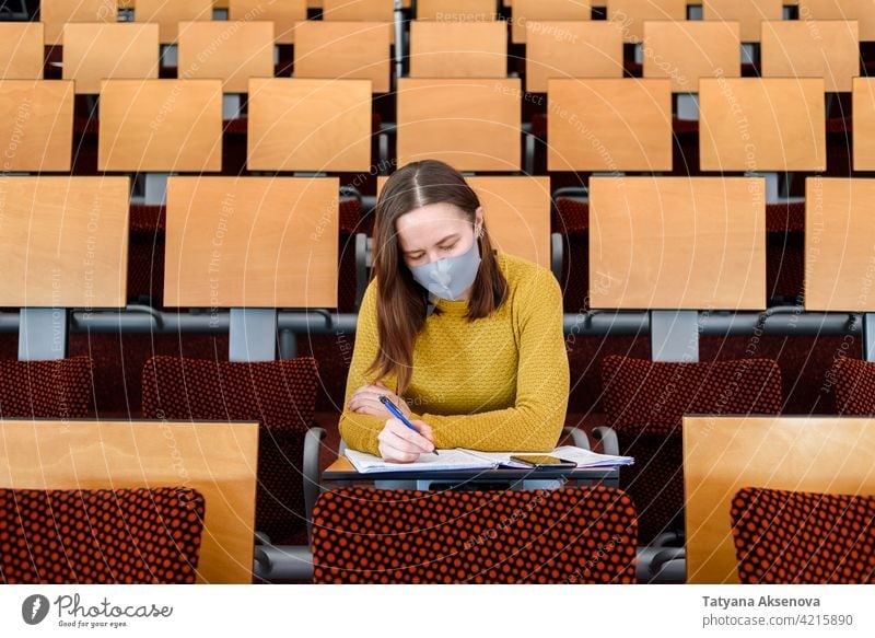 Woman student sitting in face mask education classroom studying back to school high school learning safety woman person indoors protection social distancing