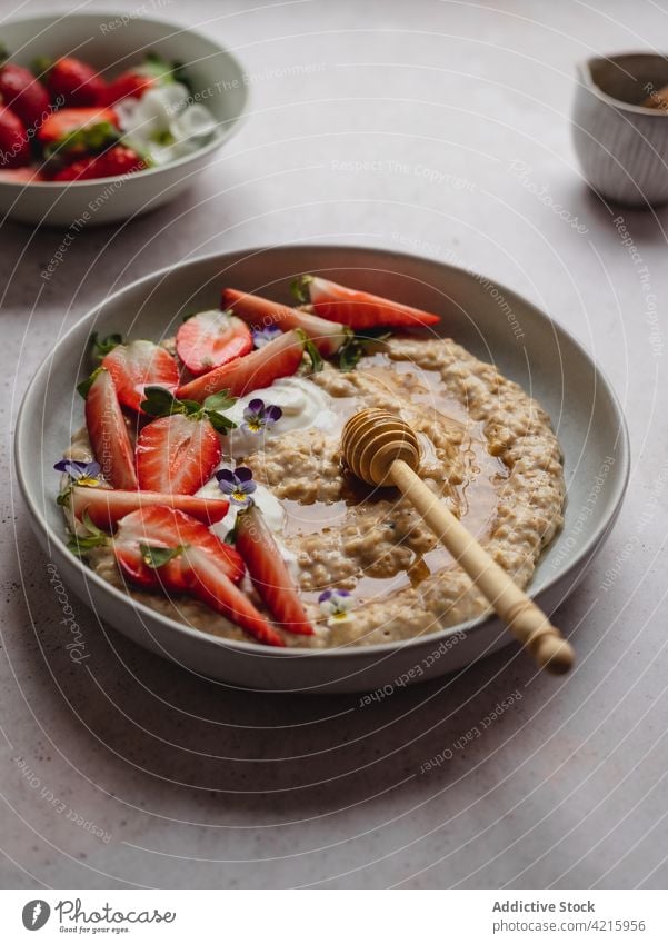 Closeup of a delicious plate of strawberry porridge food oatmeal breakfast healthy fruit cereal bowl granola snack white sweet vegetarian table flakes nutrition