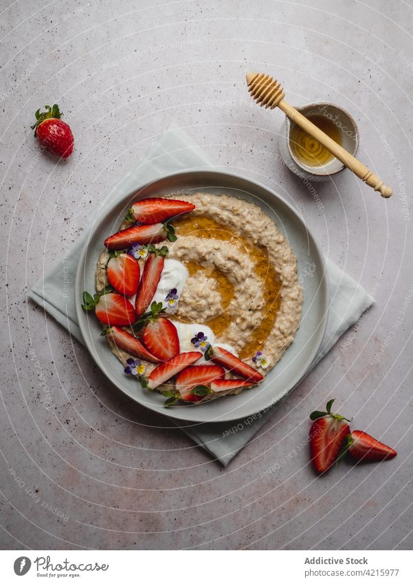Closeup of a delicious plate of strawberry porridge food oatmeal breakfast healthy fruit cereal bowl morning granola diet snack white sweet vegetarian table
