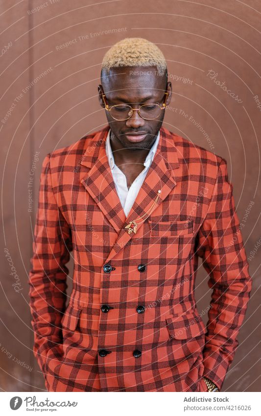 Stylish black man in tartan jacket and eyeglasses fashion style hand in pocket individuality checkered melancholy cool portrait well dressed masculine macho