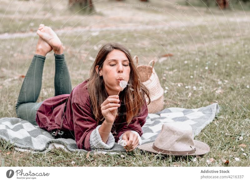 Woman blowing dandelion in forest during picnic woman nature enjoy carefree flower blanket female australia relax summer park holiday woods weekend chill