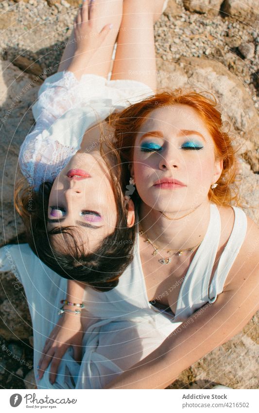 Sensual lesbian women with makeup on wedding day couple homosexual relationship eyes closed sensual mindfulness eyeshadow portrait tender rough land newlywed