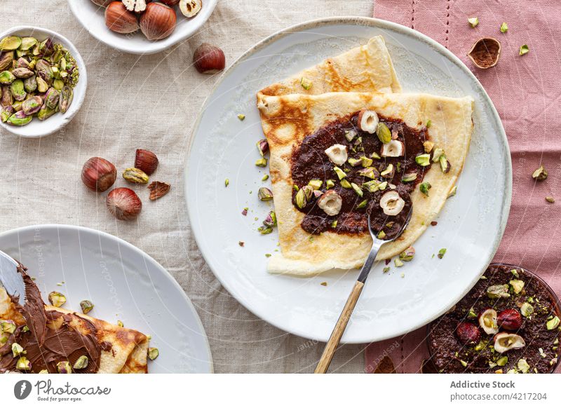 Appetizing crepes with chocolate on plate breakfast serve nut dish table morning homemade dessert delicious sweet tasty food treat gourmet fresh nutrition