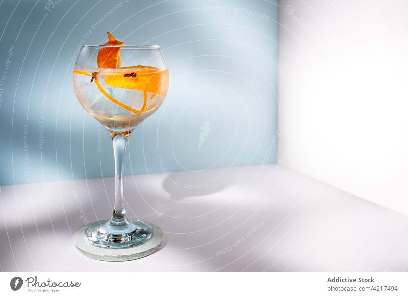 Glass of gin tonic with orange zest on table cocktail alcohol highball clove glass shadow scent bright creative design water aroma citrus alcoholic drink