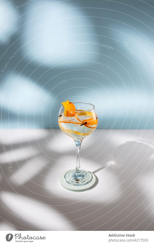 Glass of gin tonic with orange zest on table cocktail alcohol highball clove glass shadow scent bright creative design water aroma citrus alcoholic drink