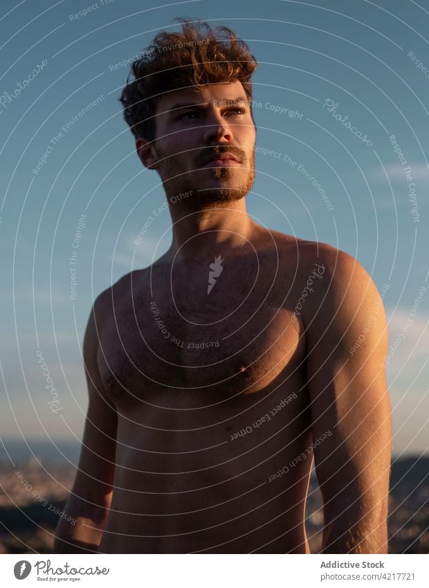 Masculine man with naked torso at sundown abdomen masculine macho fit body cloudy highland sunset brutal shirtless six pack abs virile mountain sky idyllic