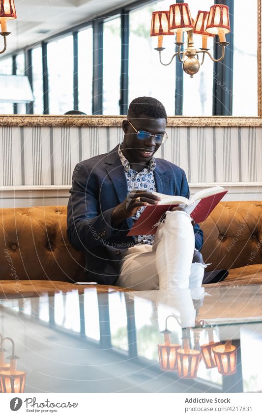 Pensive black businessman reading book in cafe entrepreneur elegant well dressed literature pensive focus male ethnic african american concentrate confident