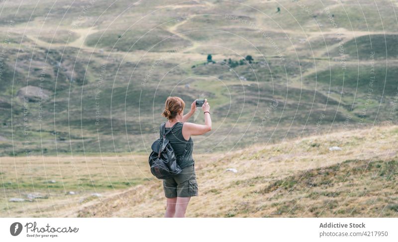Unrecognizable hiker taking photo of landscape on smartphone take photo nature hill explore wanderlust woman using gadget device rucksack travel journey