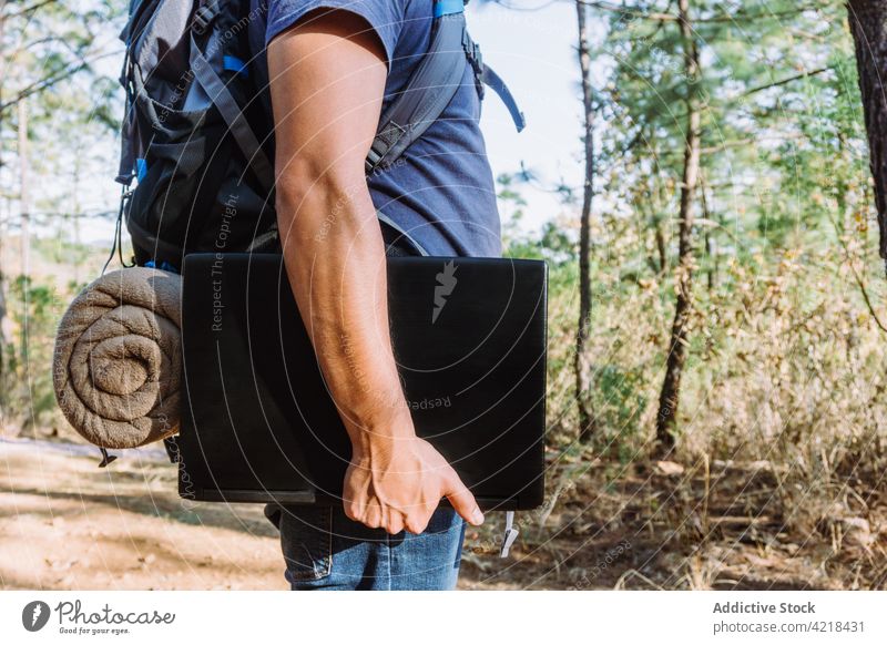 Man with backpack and laptop standing in forest man nomad digital freelance woods travel nature distance trekking male belonging backpacker tree device tourism