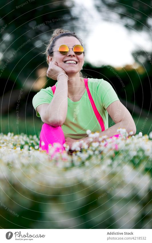 Happy woman sitting on lush grassy meadow joy charismatic carefree countryside glade nature outfit toothy smile expressive fun bright happy cheerful satisfied