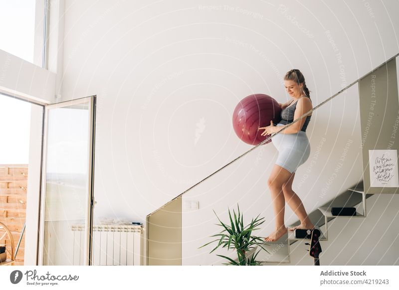 Pregnant woman with exercise ball walking on stairs at home yoga pregnant maternal smile await sport fitness belly pregnancy tummy motherhood wellness vitality