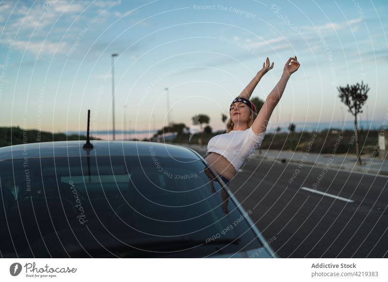 Happy woman enjoying road trip car freedom american happy window travel journey female sunset carefree usa young lifestyle vacation evening traveler arms raised
