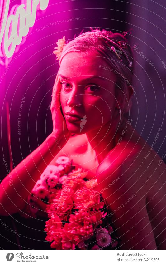 Stylish woman with flowers in studio with neon lights bouquet style portrait color elegant bare shoulders floral female bright colorful natural fresh creative