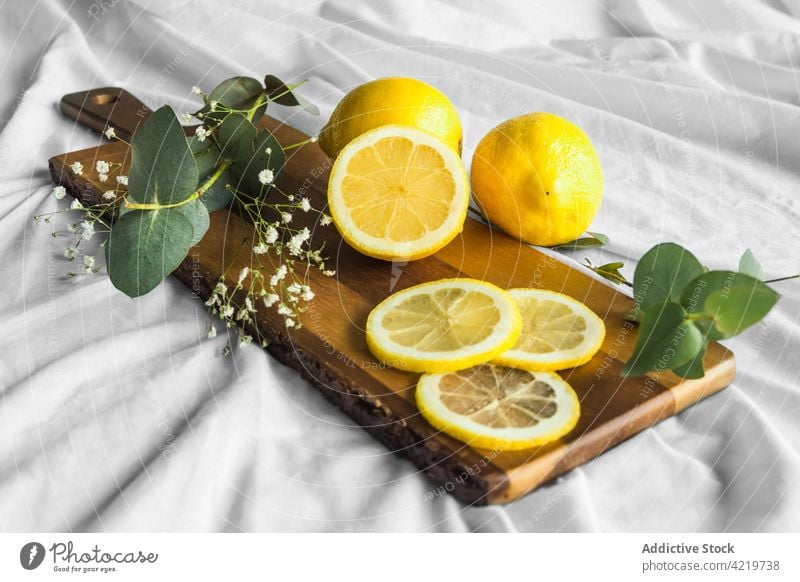 Bright fresh lemons with leaves on cutting board leaf fruit ripe natural zero waste bag textile colorful foliage sprig plant eco vitamin whole eco friendly