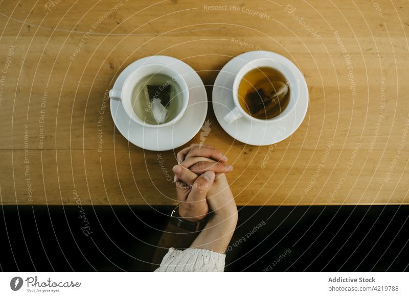 Loving couple holding hands in cafe tea table love relationship together drink romantic beverage sit date mug cup hot boyfriend girlfriend tender bonding