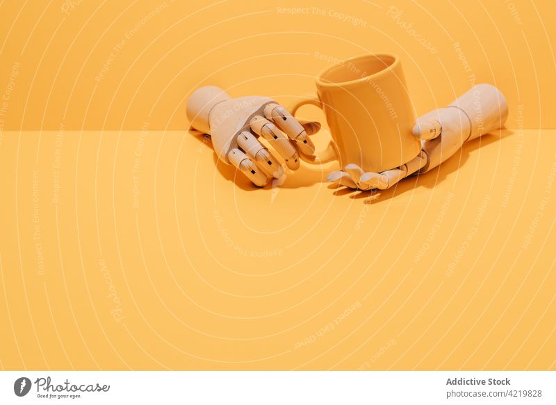 Wooden hand with coffee cup on yellow background wooden concept mug studio design beverage creative minimal object simple utensil color style tea breakfast